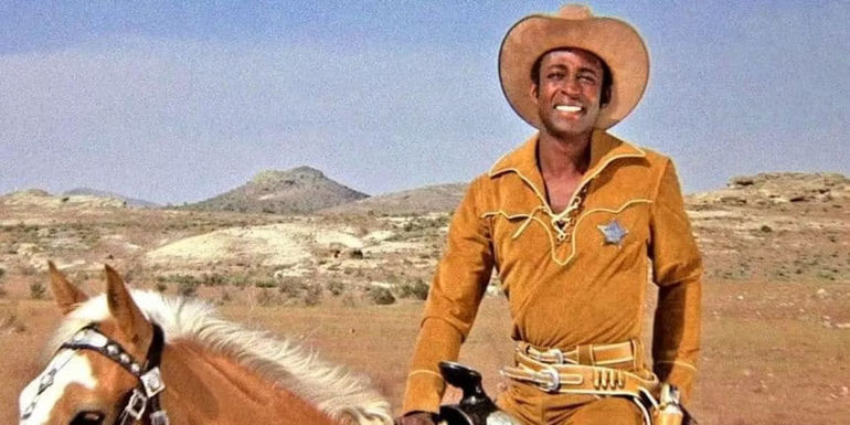 Cleavon Little as Sheriff Bart smiling and sitting atop a horse in a still from Blazing Saddles