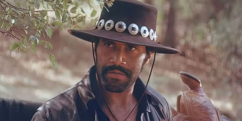 Fred Williamson as Joshua looks menacingly at an off screen opponent while next to his horse in Joshua