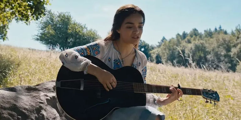 Lucy Gray is playing the guitar outside in The Ballas of Songbirds and Snakes.