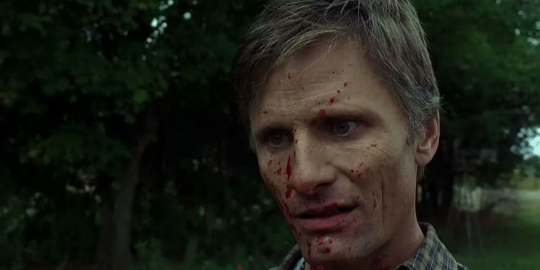 Joey Cusak/Tom Stall stands in bewilderment with human blood spattered across his face in A History of Violence