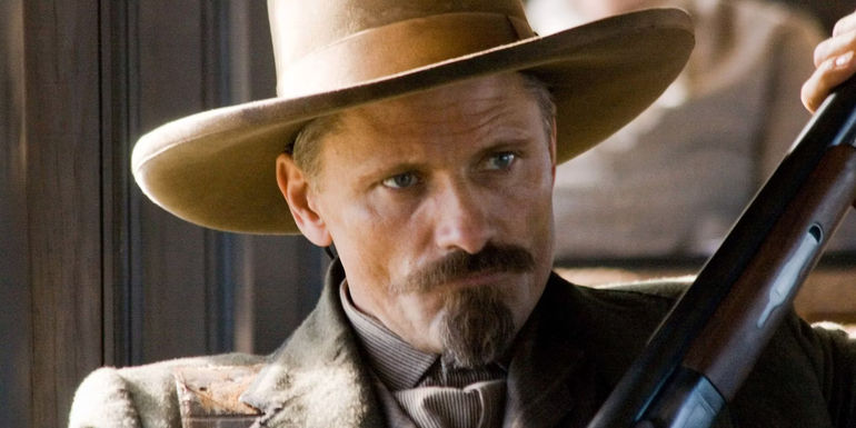 Viggo Mortensen as Virgil Cole, angrily clutching his rifle while contemplating his next move in 2008's Appaloosa