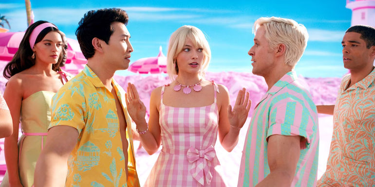 Margot Robbie as Barbie standing between Simu Liu and Ryan Gosling as the two Ken's argue
