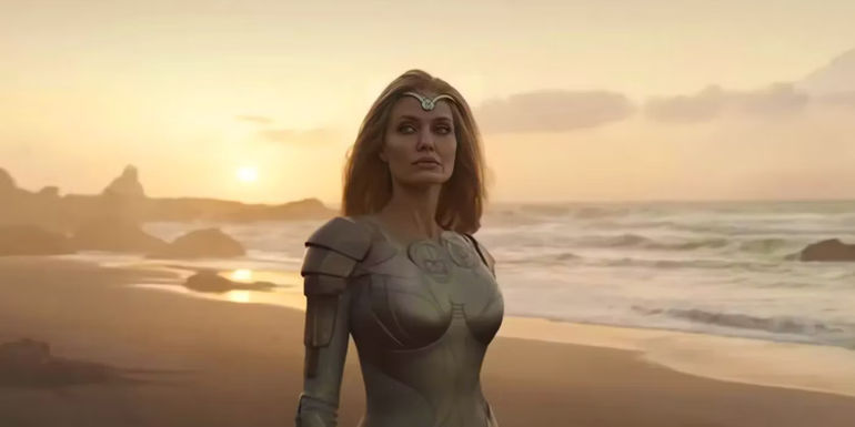 Thena (Angelina Jolie) looks to the side on a beach in The Eternals