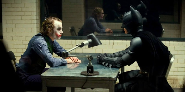 Heath Ledger's Joker and Christian Bale's Batman in an interrogation room in The Dark Knight