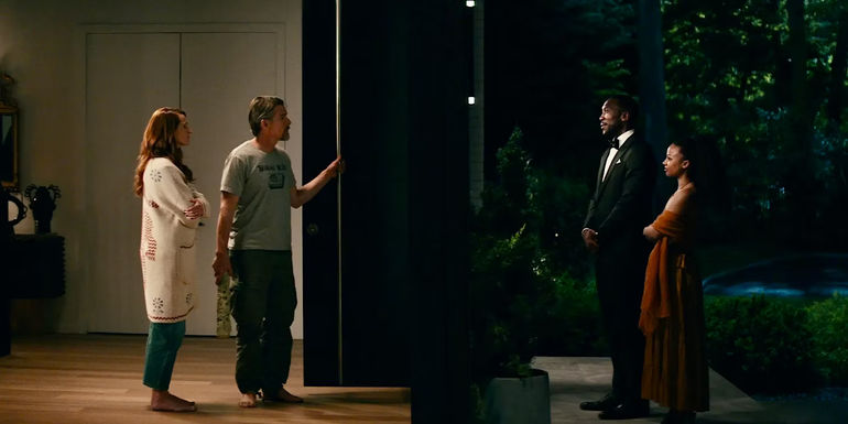 The Scotts standing in front of the Sandfords, with the door open in Leave the World Behind.