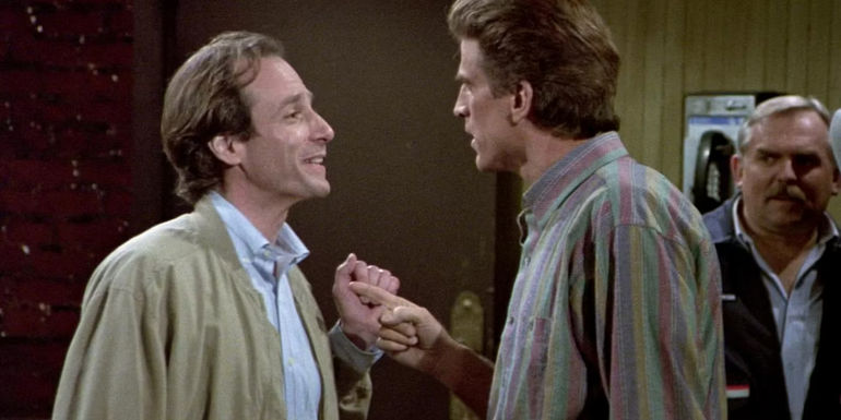 Gary (Robert Desiderio) laughing at Sam (Ted Danson) who's pointing a finger in Cheers.