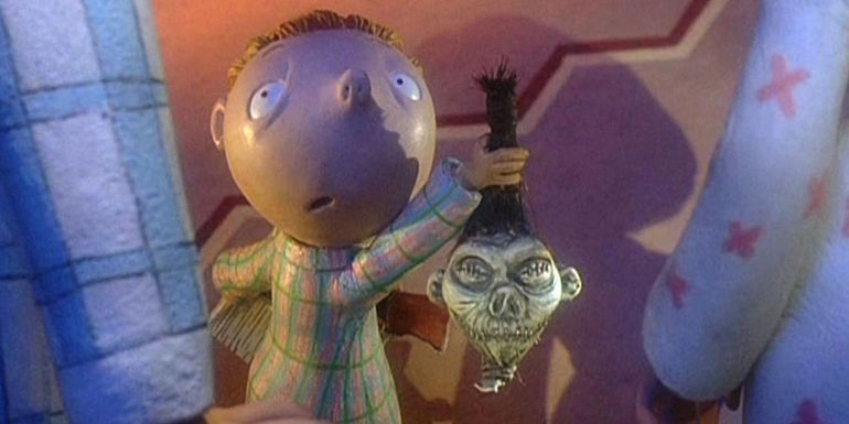 A young boy holding up a shrunken head to his parents in The Nightmare Before Christmas