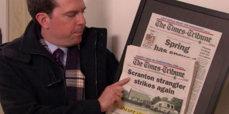 Andy holds up a newspaper with the headline,