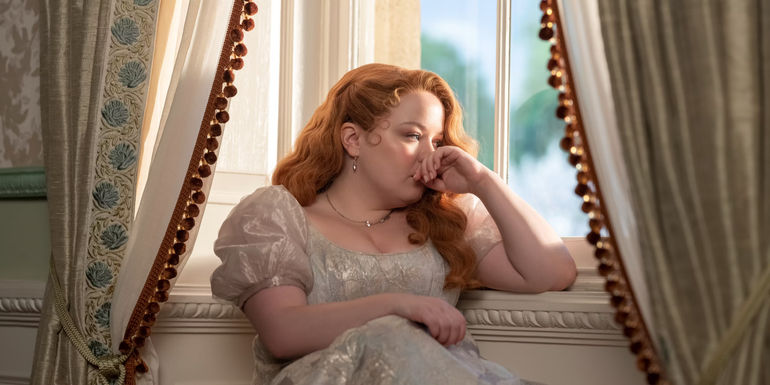 Nicola Coughlan's Penelope sitting by the window thinking in Bridgerton season 3