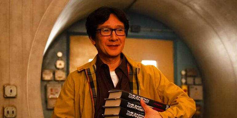 AD Doug/Ouroboros (Ke Huy Quan) holds his books in Loki Season 2