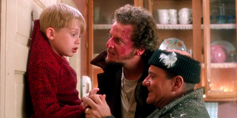Two burglars have caught Kevin and pinned him to a door hook in Home Alone