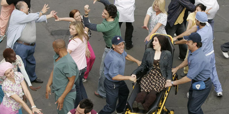 Patti Miller Surrounded by Hospital Staff in Scrubs