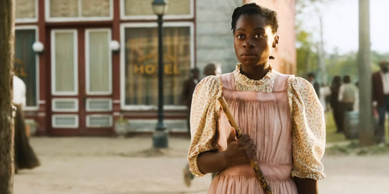Phylicia Pearl Mpasi as a young Celie holding a broom in The Color Purple