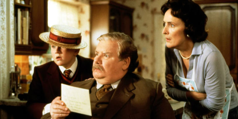Dudley, Vernon, and Petunia Dursley stare at Harry in Harry Potter and the Sorcerer's Stone