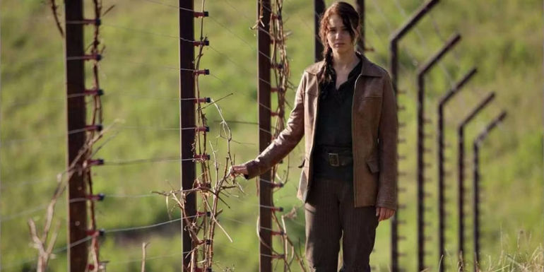 Katniss walking on the edge of District 12 in The Hunger Games