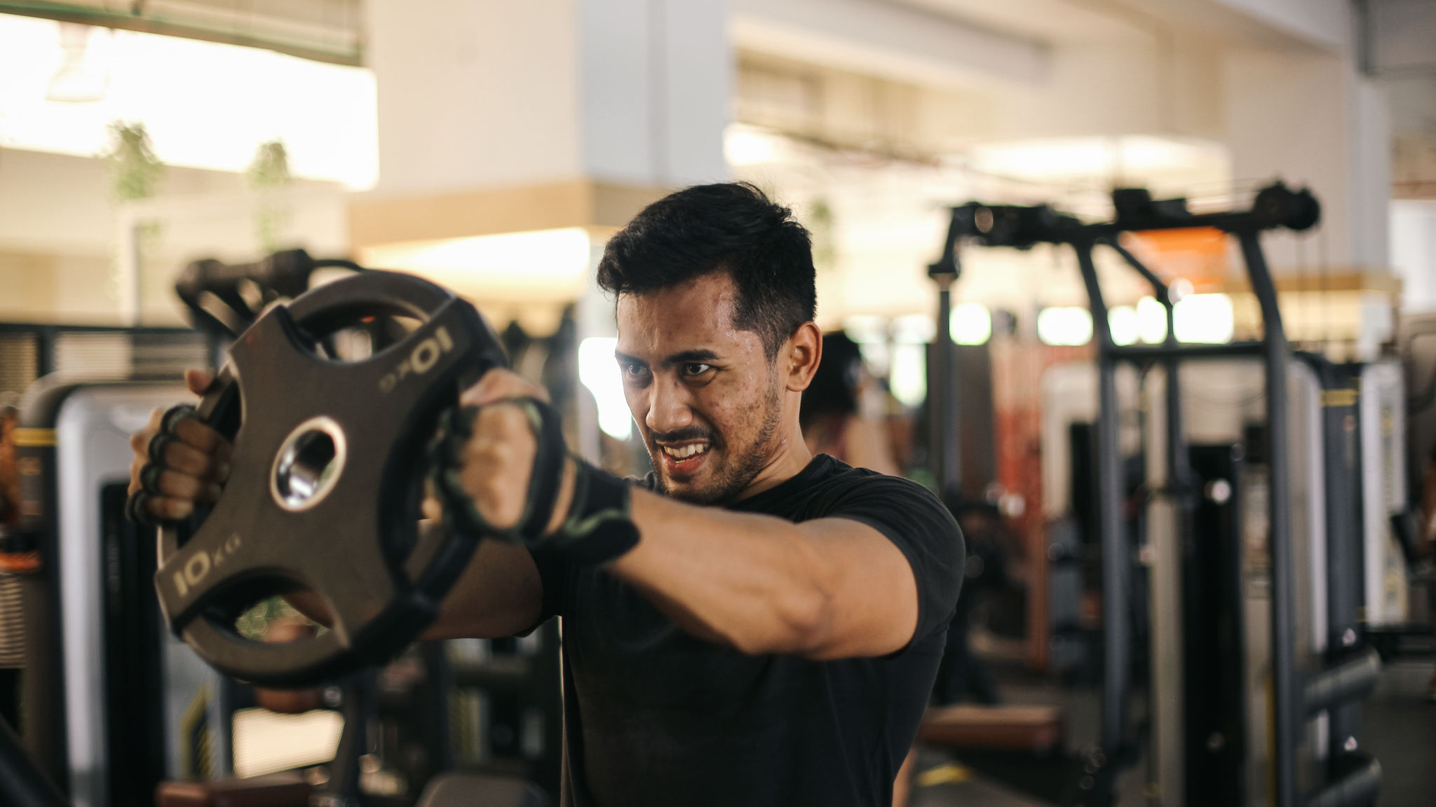 Young Asian man bodybuilder doing workout at gym