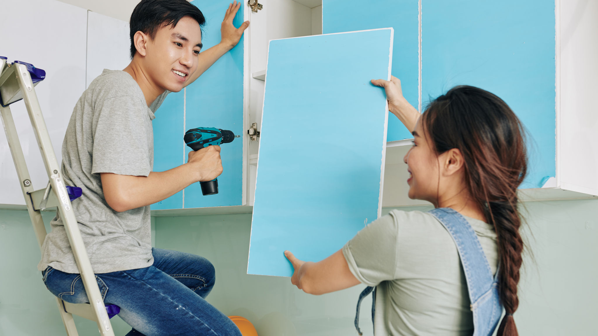 Couple assembling cupboard together    