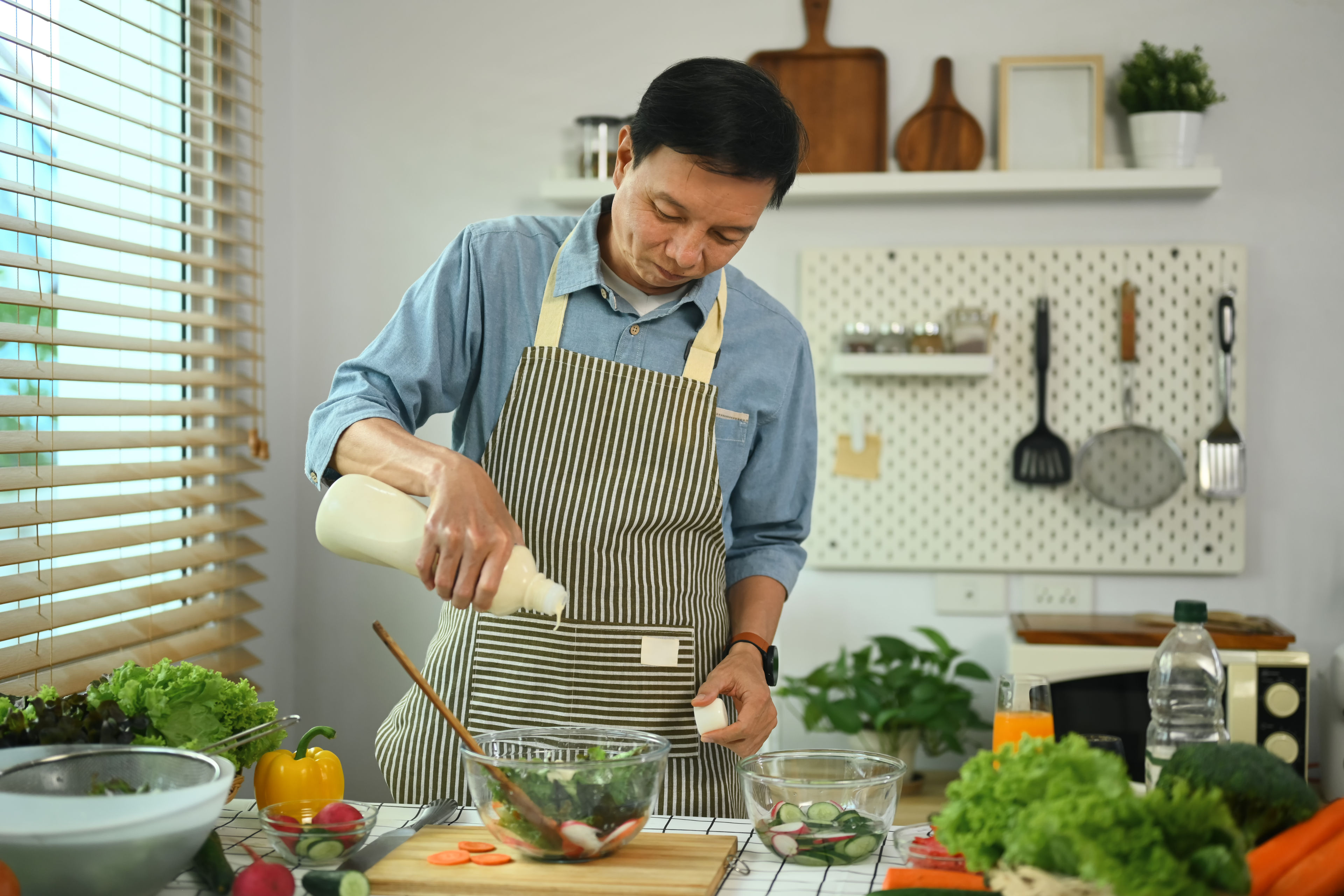 A middle aged man cooking in the kitchen 