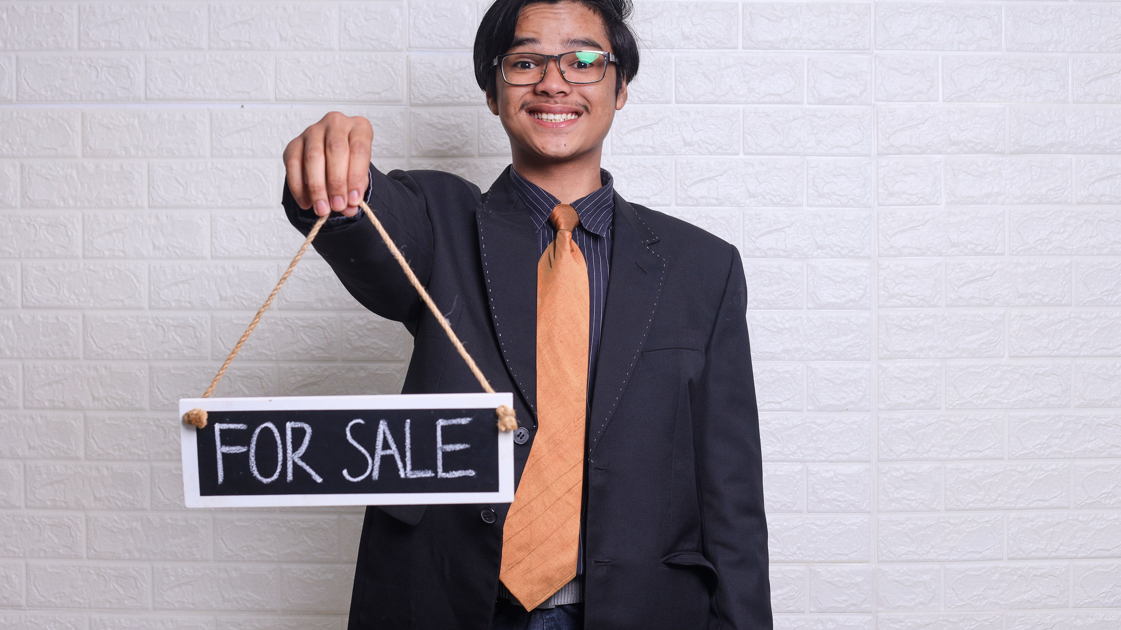 Young man holding a sale card.