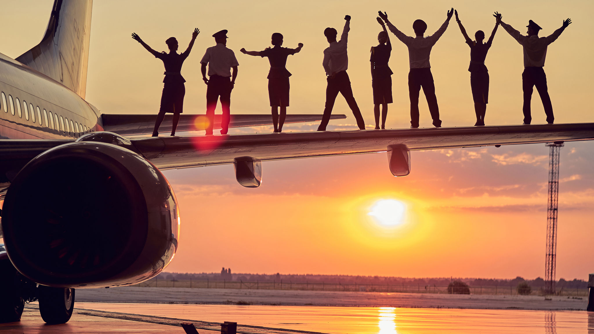 People holding hands on a flight winglet