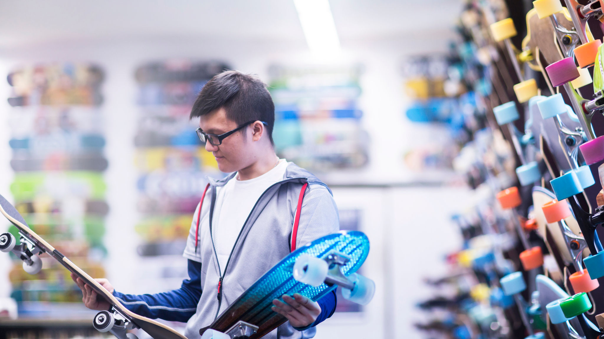 Young male skateboarder looking at skateboards