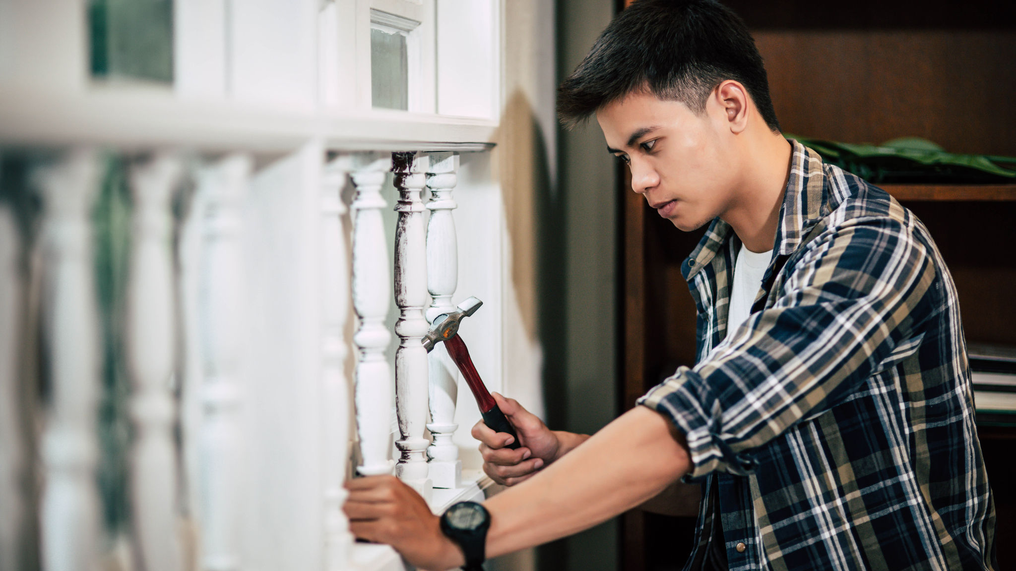 The carpenter holds the hammer and nails.