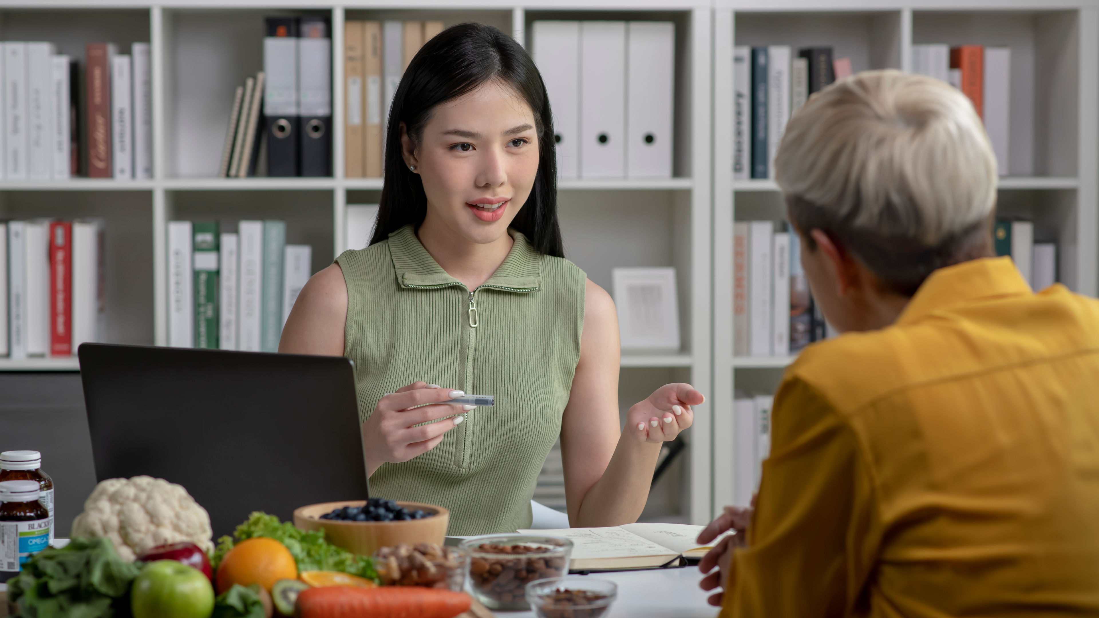 Nutritionist with woman client talking about meal plan and healthy products 