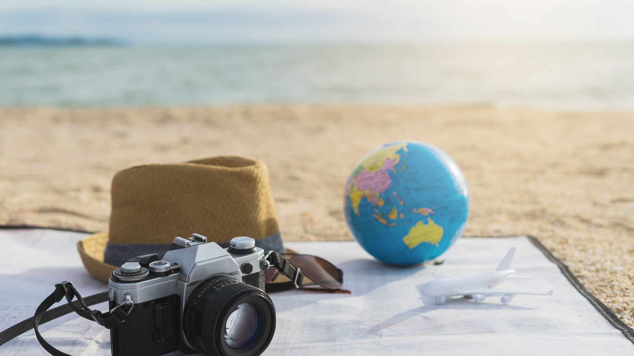 Camera, sumbrero at salaming pang araw sa beach 