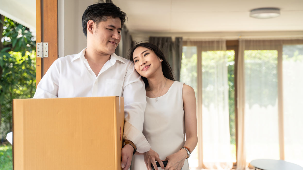 asian-couple-moving-to-new-house-man-holding-big-2022-01-19-00-15-05-utc