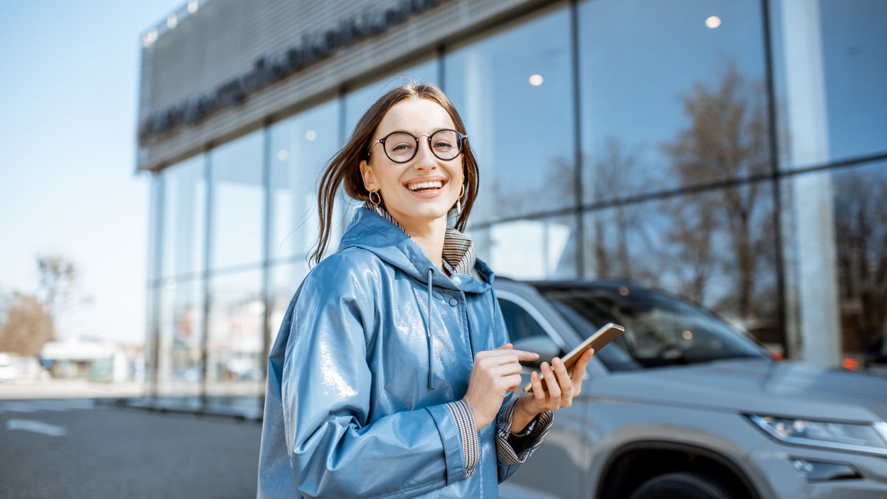 woman-with-phone-near-the-car-outdoors-2022-01-19-00-03-52-utc