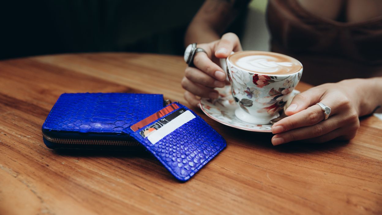 woman-in-cafe-drinking-cappuccino-with-wallet-and-2022-11-14-05-04-14-utc