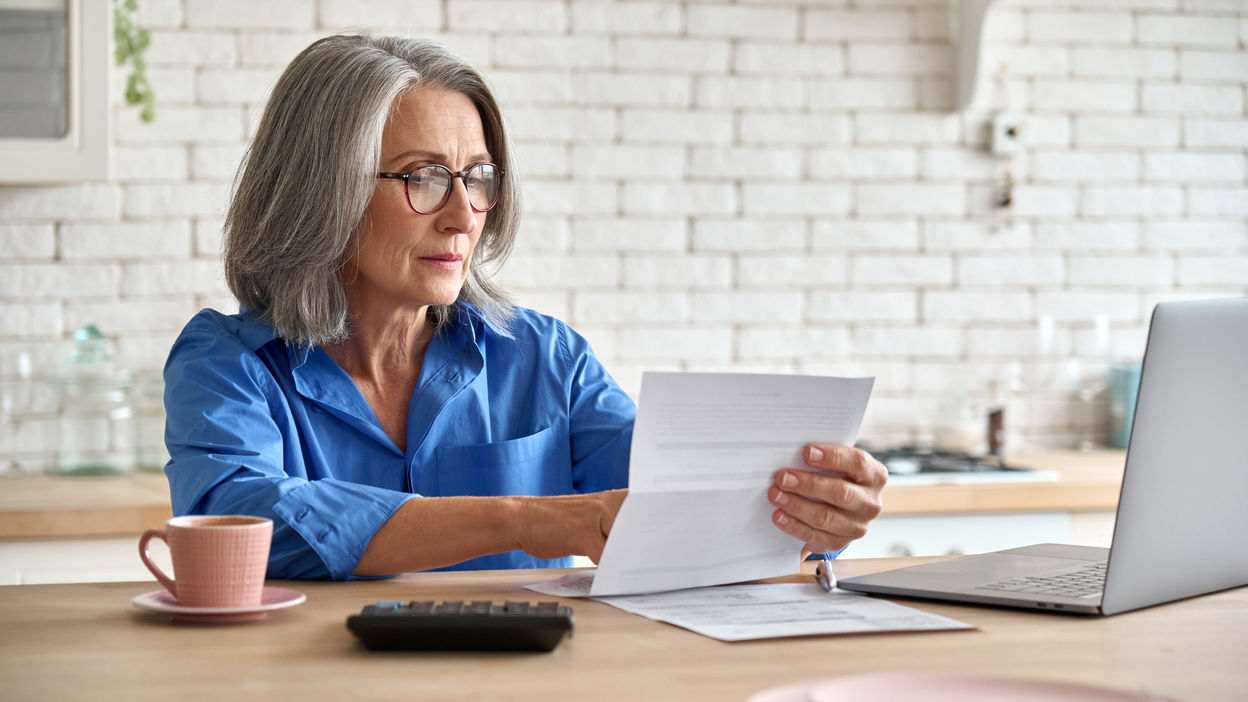 senior-mid-60s-aged-woman-calculating-bank-fee-wit-2021-09-02-07-15-58-utc