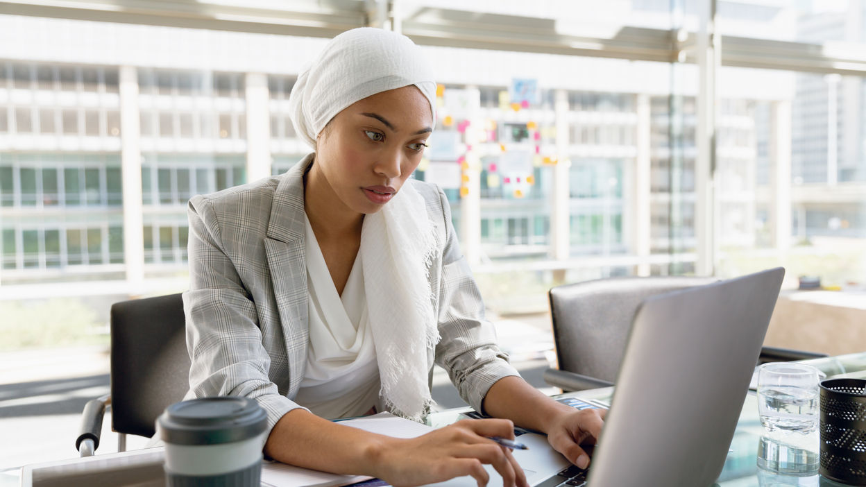 businesswoman-in-hijab-working-on-laptop-at-desk-i-2023-11-27-05-04-44-utc