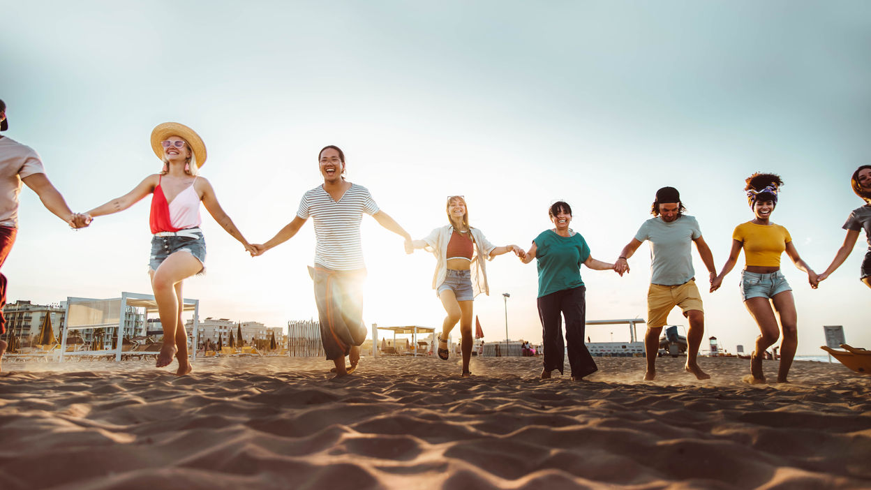 group-of-people-holding-hands-running-on-the-beach-2022-12-17-03-38-31-utc