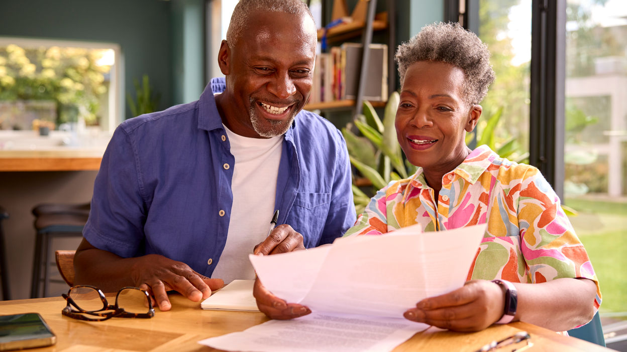 smiling-senior-couple-sitting-around-table-at-home-2022-09-08-18-52-33-utc