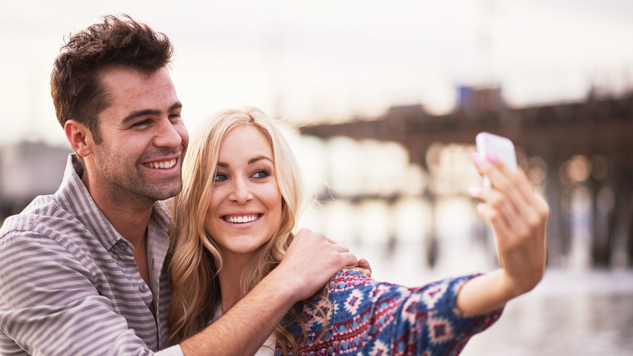 cute-couple-taking-selfies-together-on-beach-2022-06-14-11-53-58-utc