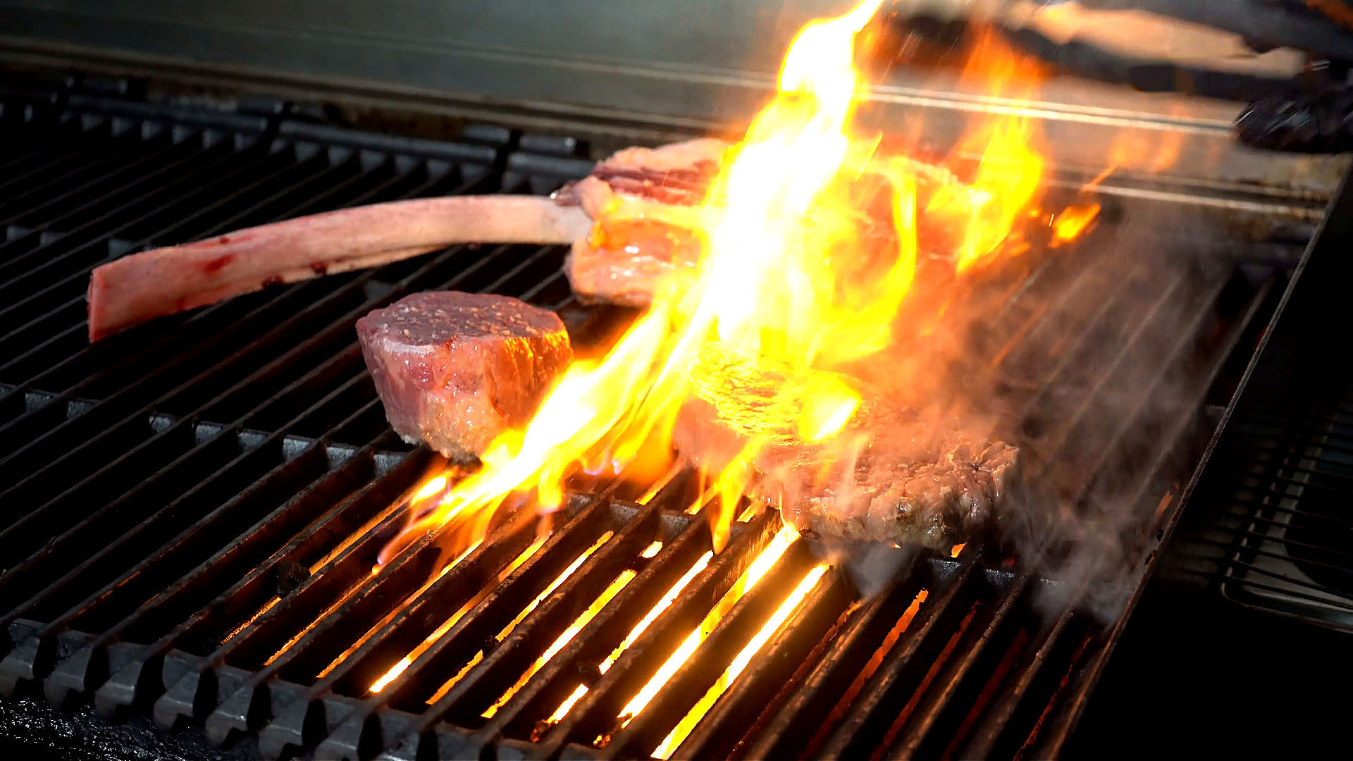 Steaks cooking over open flame at Asado Steakhouse