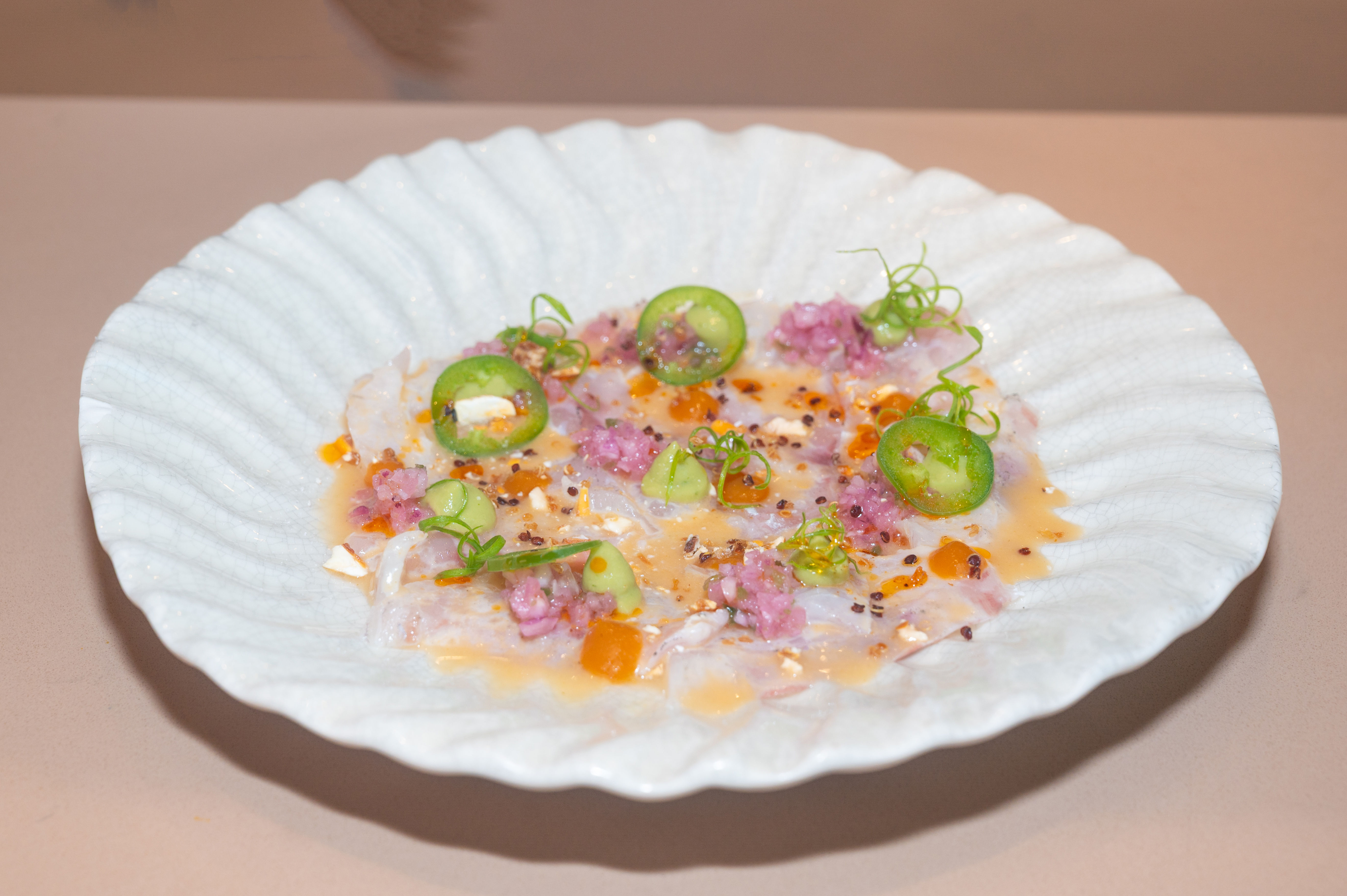 Chef Roberto Segura preparing a dish at Crudo in Dubai