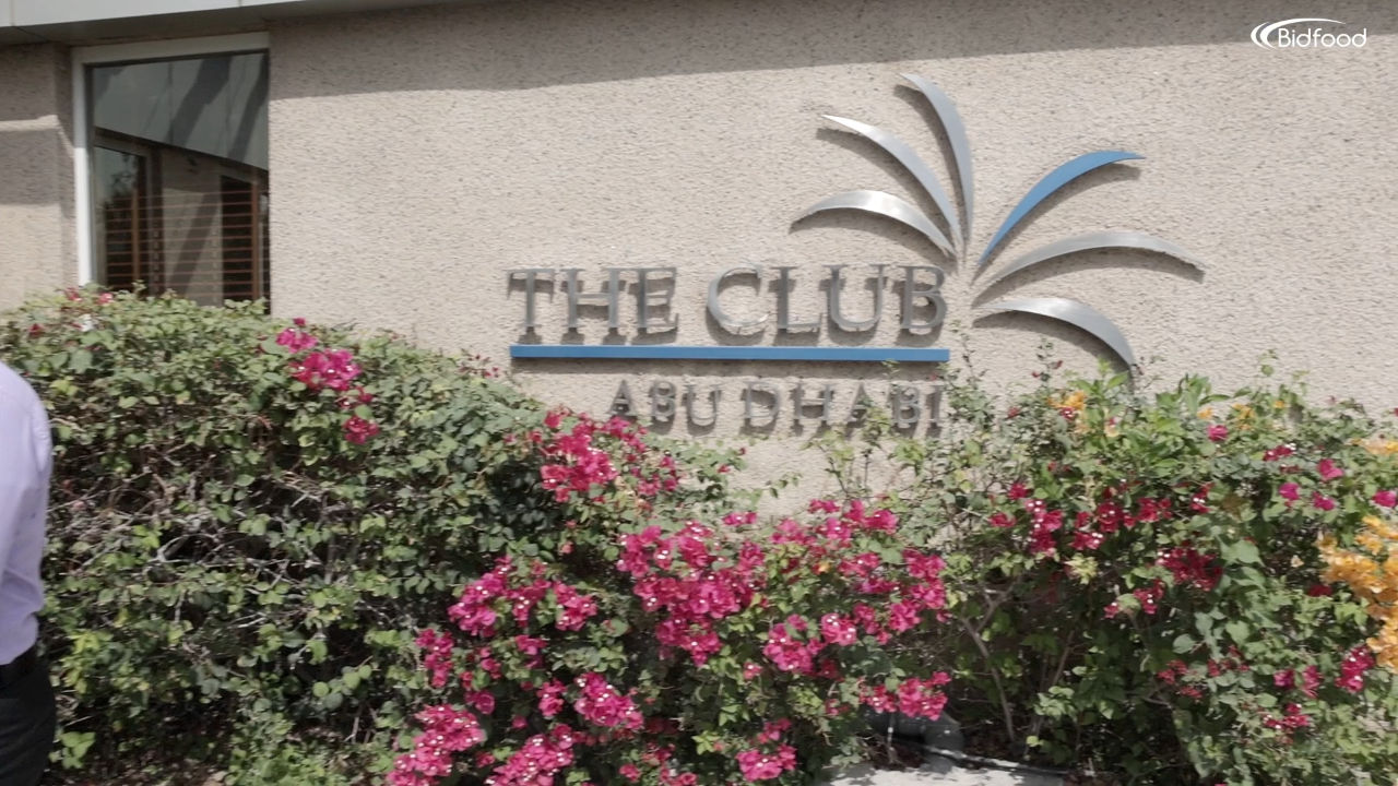The Club Abu Dhabi sign surrounded by flowers