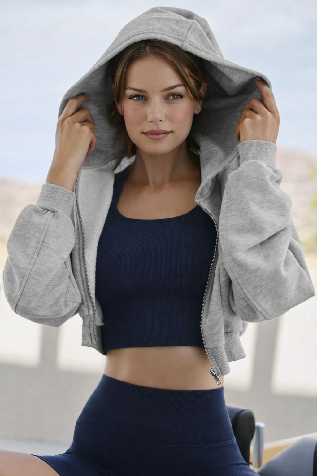 Trendy young woman in a cropped hoodie, styled for streetwear fashion in 2026 with a mix of sporty and elegant elements.