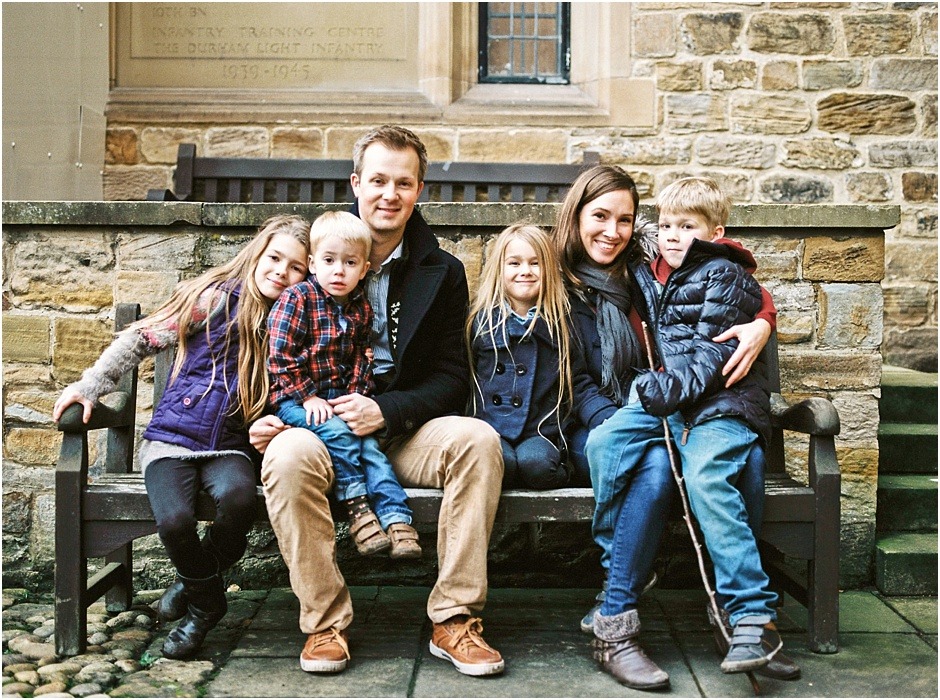 Family portrait on a bench outside Durham Catherdral in winter.