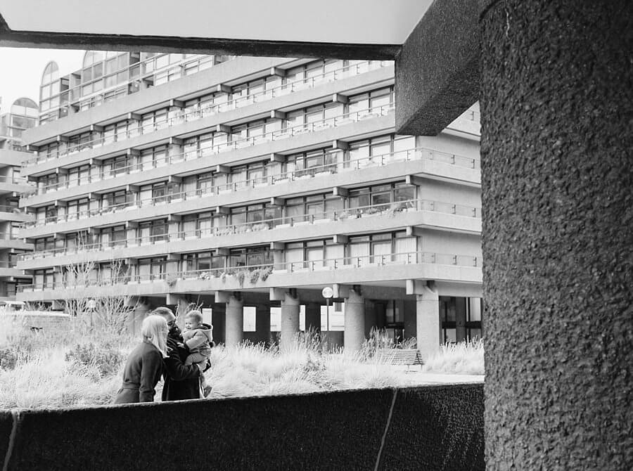 Black and white image of family framed by brutalist building architecture