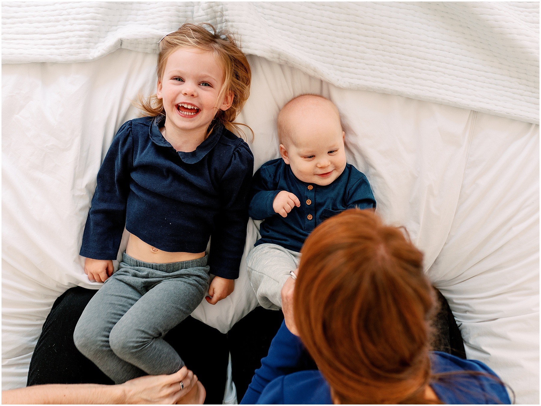 Sibling on bed laughing