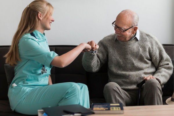 old-man-nursing-home-fist-bumping-nurse 1