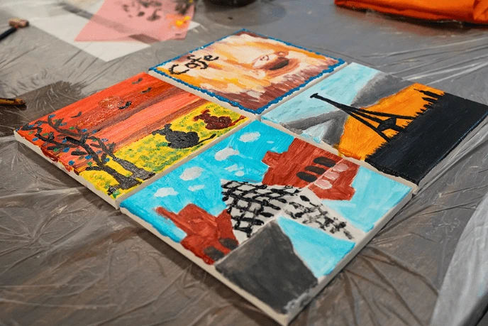 Four finished canvases laid out to dry after a session