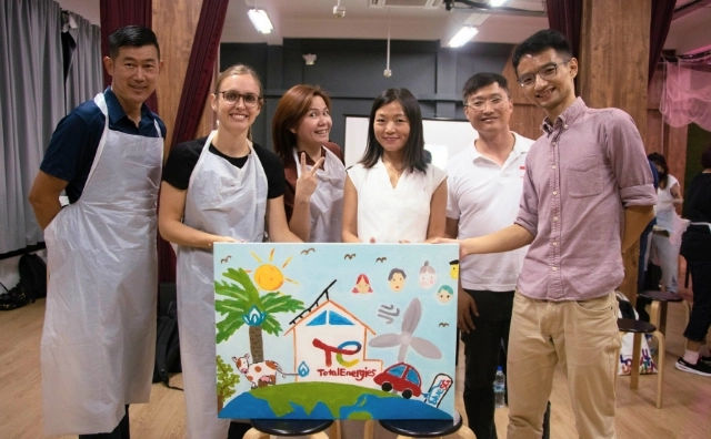 Painters working on canvases at an art jamming session in Singapore