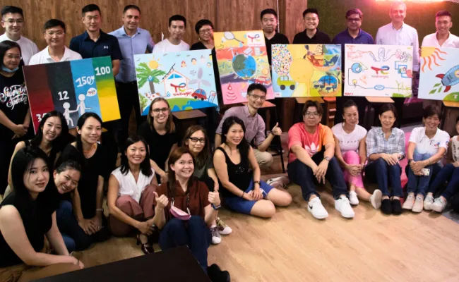 A team painting one large collaborative canvas together