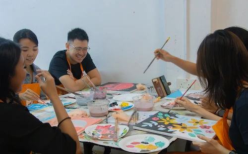 A first-time painter beside their finished acrylic canvas