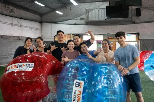 friends playing bubble soccer together for fun
