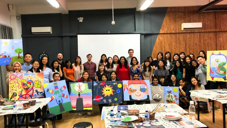 A full room of painters at easels during a session